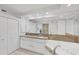 Bathroom featuring a large mirror, double sinks, granite countertops, a soaking tub, and a shower at 7334 Regina Royale # 74, Sarasota, FL 34238