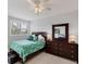 Bedroom featuring a dresser with a mirror, a window with blinds, and tropical themed linens at 7334 Regina Royale # 74, Sarasota, FL 34238