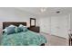 Bedroom with tropical bedding, dresser, and closet space, offering a relaxing and organized retreat at 7334 Regina Royale # 74, Sarasota, FL 34238