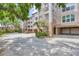 Exterior angle featuring the condominium and garage with matured landscaping at 7334 Regina Royale # 74, Sarasota, FL 34238