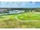 High angle shot of the golf course, with winding paths and mature landscaping surrounding a serene pond at 7334 Regina Royale # 74, Sarasota, FL 34238