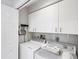 Well-lit laundry room with white cabinets, washer, dryer, and ample storage space for household tasks at 7334 Regina Royale # 74, Sarasota, FL 34238