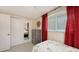 Cozy bedroom with tiled floor, nautical accents, closet, and window with bright red curtains at 755 Taplow Rd, Venice, FL 34293