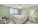 Charming bedroom with soft green walls, a cozy chair, and a comfortable bed at 755 Taplow Rd, Venice, FL 34293