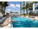 Outdoor pool surrounded by palm trees and lounge chairs with the condo in the background at 777 N Ashley Dr # 1712, Tampa, FL 33602