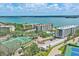 Stunning aerial showcasing waterfront community, tennis courts, pool, and lush greenery at 8701 Midnight Pass Rd # 206A, Sarasota, FL 34242