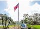 Turtle Bay community entrance with American flag and tropical landscaping at 8701 Midnight Pass Rd # 206A, Sarasota, FL 34242