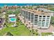 Beautiful condo building overlooking a sparkling pool, lush green lawn, and swaying palm trees at 8701 Midnight Pass Rd # 206A, Sarasota, FL 34242