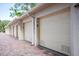 Row of garages with brick-paved driveway, providing private parking for residents at 8701 Midnight Pass Rd # 206A, Sarasota, FL 34242