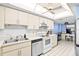 Bright kitchen with white appliances and tile floors featuring tons of cabinet and counter space at 8701 Midnight Pass Rd # 206A, Sarasota, FL 34242
