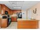 Clubhouse kitchenette with wooden cabinets, granite countertop, and black appliances at 8701 Midnight Pass Rd # 206A, Sarasota, FL 34242