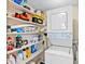 Convenient laundry area features a stacked washer and dryer, along with shelving for storage at 8701 Midnight Pass Rd # 206A, Sarasota, FL 34242