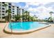 Large community pool with lounge chairs and lush tropical landscaping at 8701 Midnight Pass Rd # 206A, Sarasota, FL 34242