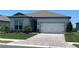 Charming single-story home featuring a brick driveway, well-manicured lawn, and a two-car garage at 8752 Coastal Key Way, Parrish, FL 34219