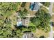 Aerial view showcases a backyard pool, green landscape and the proximity to nature and nearby homes at 906 134Th E St, Bradenton, FL 34212