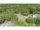 A beautiful aerial view of a home with a pool, a pond, and stunning landscaping and mature trees at 906 134Th E St, Bradenton, FL 34212