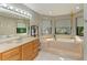 Bright bathroom features a large soaking tub, double windows, and a vanity at 906 134Th E St, Bradenton, FL 34212