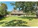 Attractive two-story home with a full, charming front porch, mature trees, and spacious front yard at 906 134Th E St, Bradenton, FL 34212