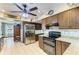 Well-equipped kitchen features stainless steel appliances, granite countertops, dark wood cabinets, and tiled floor at 906 134Th E St, Bradenton, FL 34212