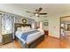 Relaxing main bedroom with a wooden bed frame, ceiling fan, and access to a bathroom at 906 134Th E St, Bradenton, FL 34212