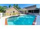 Backyard pool with brick trim and an umbrella surrounded by well-maintained landscaping offers a resort-style escape at 906 134Th E St, Bradenton, FL 34212