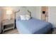 Cozy bedroom with a comfortable blue bed, stylish nightstand, and a view of the ensuite bathroom at 8752 Coastal Key Way, Parrish, FL 34219