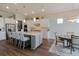 Bright and open kitchen featuring a large island with seating, stainless steel appliances, and ample counter space at 8752 Coastal Key Way, Parrish, FL 34219