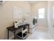 Functional laundry room with modern washer and dryer, folding table, and ample storage space at 8752 Coastal Key Way, Parrish, FL 34219