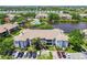 An aerial view of an apartment complex with a pond and community pool area in a sunny, landscaped setting at 10265 Gandy N Blvd # 1004, St Petersburg, FL 33702