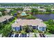 An aerial view of an apartment complex with a pond and community pool area in a sunny, landscaped setting at 10265 Gandy N Blvd # 1004, St Petersburg, FL 33702