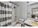 Clean bathroom features a tub with striped shower curtain, toilet, and sink with mirror at 10265 Gandy N Blvd # 1004, St Petersburg, FL 33702