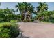 Elegant entrance with manicured landscaping, mature palm trees and brick-paved roundabout at 10265 Gandy N Blvd # 1004, St Petersburg, FL 33702