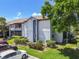 Exterior view of the condo with lush landscaping, a partial view of a pond, and a blue sky background at 10265 Gandy N Blvd # 1004, St Petersburg, FL 33702