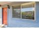 Condo's entrance with orange door, exterior light, and window, showing the welcoming features of the home at 10265 Gandy N Blvd # 1004, St Petersburg, FL 33702