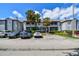 Condo exterior view showing a well-maintained parking area, manicured landscaping, and a sunny sky at 10265 Gandy N Blvd # 1004, St Petersburg, FL 33702