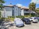 Exterior of condo with a parking area and a few cars parked along with lush landscaping at 10265 Gandy N Blvd # 1004, St Petersburg, FL 33702