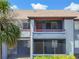 Exterior of condo, with a shaded front porch, lush landscaping, and well-maintained parking area in front at 10265 Gandy N Blvd # 1004, St Petersburg, FL 33702