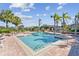 Community pool surrounded by lounge chairs, palm trees, and landscaping on a sunny day at 10265 Gandy N Blvd # 1004, St Petersburg, FL 33702