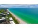 Aerial view of beachfront condos, a sandy beach and shimmering turquoise water at 1211 Gulf Of Mexico Dr # 704, Longboat Key, FL 34228