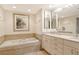 Bathroom features a soaking tub with marble surround, white cabinets, and dual sinks at 1211 Gulf Of Mexico Dr # 704, Longboat Key, FL 34228