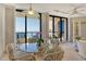 Cozy dining area with seating for four, featuring ocean views from the adjacent balcony and natural light at 1211 Gulf Of Mexico Dr # 704, Longboat Key, FL 34228
