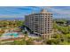 Exterior aerial view of a beachfront condominium with a pool and lush landscaping at 1211 Gulf Of Mexico Dr # 704, Longboat Key, FL 34228