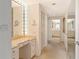 Hallway leads to the vanity and bathroom featuring a makeup mirror with Hollywood-style lighting at 1211 Gulf Of Mexico Dr # 704, Longboat Key, FL 34228