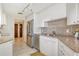 Galley kitchen featuring white cabinets, granite countertops, and stainless steel appliances at 1211 Gulf Of Mexico Dr # 704, Longboat Key, FL 34228