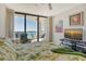 Bright main bedroom features balcony access with ocean views, a TV, and light green patterned decor at 1211 Gulf Of Mexico Dr # 704, Longboat Key, FL 34228