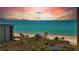 Scenic ocean view with a condo building, and palm trees on a sunny day at 1211 Gulf Of Mexico Dr # 704, Longboat Key, FL 34228