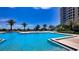 Bright swimming pool with blue skies and palm trees surrounding at 1211 Gulf Of Mexico Dr # 704, Longboat Key, FL 34228