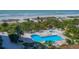Beautiful pool area with sun loungers, palm trees, and beach views at 1211 Gulf Of Mexico Dr # 704, Longboat Key, FL 34228