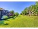 Large backyard with lush green grass and mature landscaping, creating a private outdoor space at 12710 Coastal Breeze Way, Bradenton, FL 34211