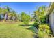 Lush backyard boasting a green lawn, mature palms, and decorative plantings surrounding the property at 12710 Coastal Breeze Way, Bradenton, FL 34211